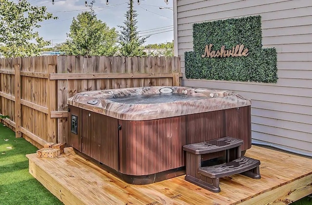 wooden deck with fence and a hot tub