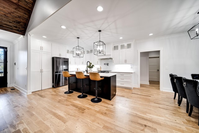 kitchen featuring light countertops, a kitchen breakfast bar, smart refrigerator, white cabinetry, and a kitchen island with sink