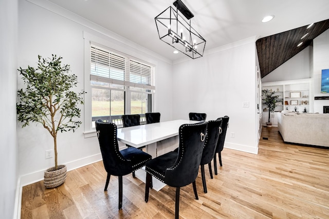 dining room with baseboards, ornamental molding, recessed lighting, light wood-style flooring, and an inviting chandelier