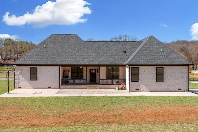 rear view of house with crawl space, a yard, and roof with shingles