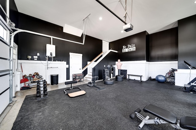 gym with a garage and a high ceiling