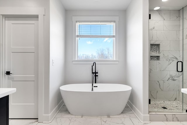 full bathroom with baseboards, a soaking tub, and marble finish floor