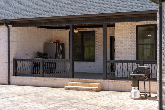 exterior space featuring brick siding, a porch, and a shingled roof