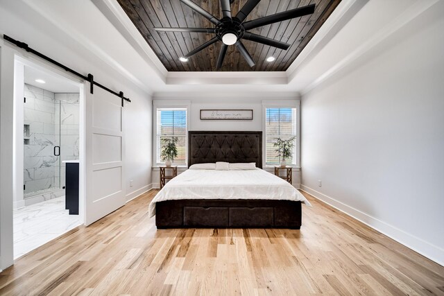 bedroom with a barn door, multiple windows, wood ceiling, and a tray ceiling