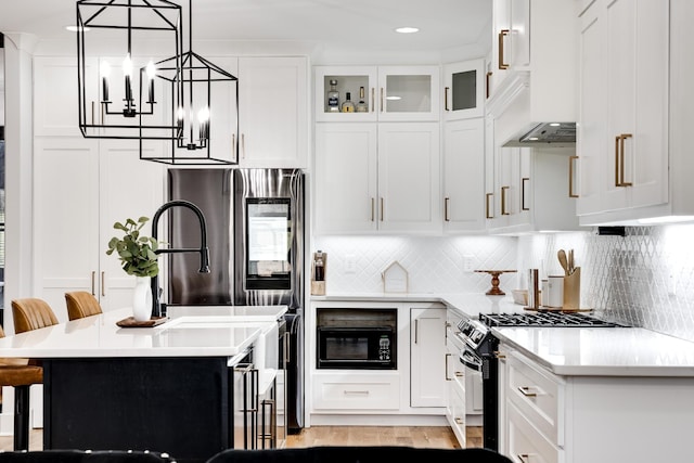 kitchen featuring decorative backsplash, a kitchen bar, gas stove, and black microwave