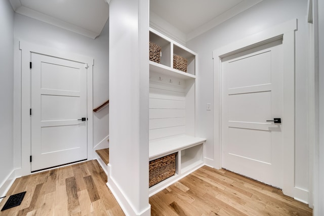 mudroom with visible vents, light wood-style flooring, and crown molding