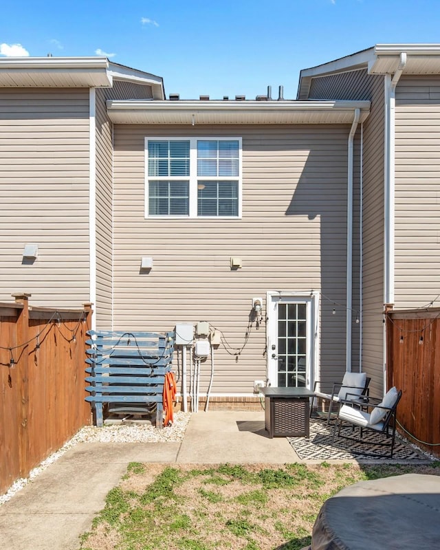 rear view of property featuring a patio area and fence