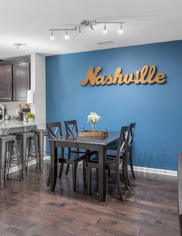 dining space featuring dark wood finished floors, visible vents, and baseboards