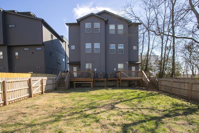 back of house with stairway, a yard, a fenced backyard, and a wooden deck