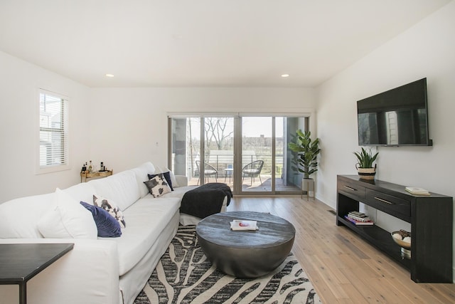 living area with recessed lighting and light wood-style floors