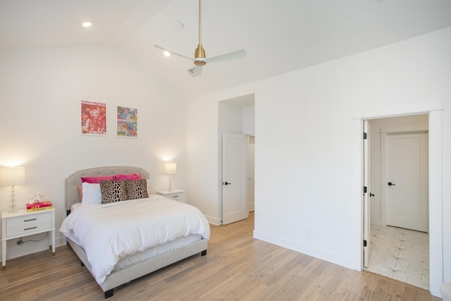 bedroom featuring light wood-type flooring, baseboards, and vaulted ceiling