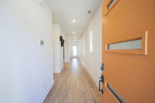 hall with light wood-style flooring, recessed lighting, visible vents, and baseboards