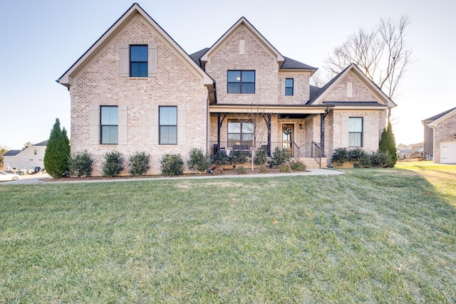 view of front facade with brick siding, covered porch, and a front lawn