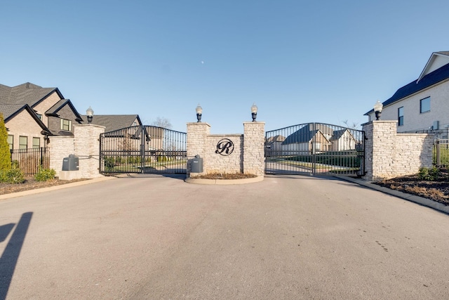 view of road featuring a gated entry, street lights, and a gate