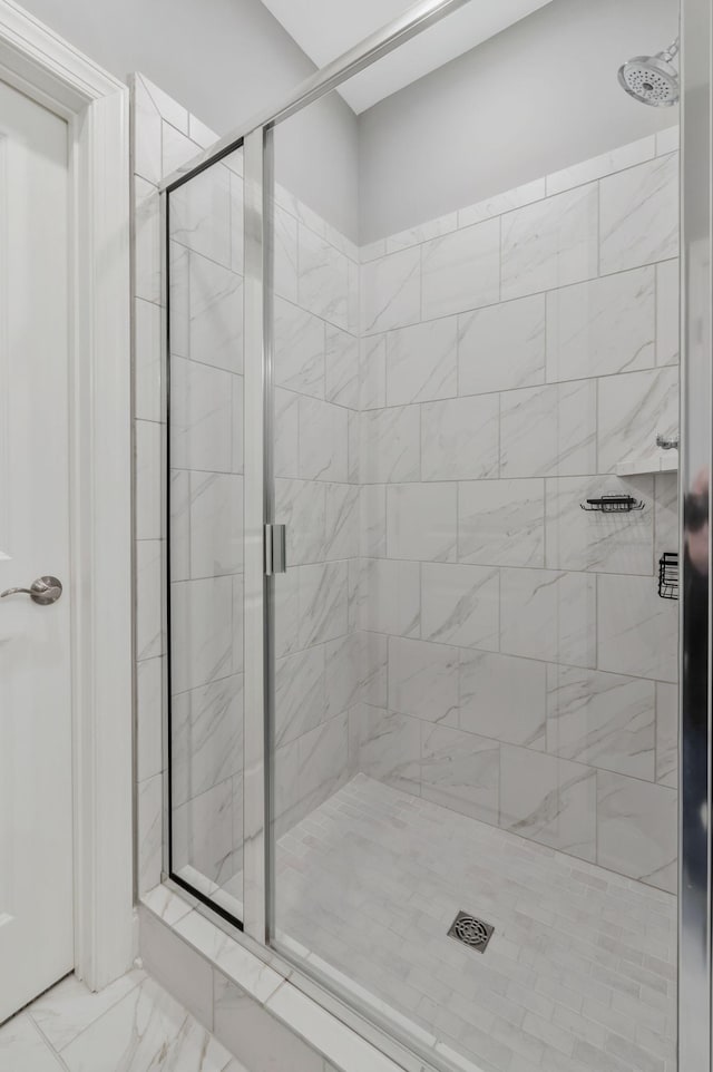 full bathroom featuring marble finish floor and a shower stall