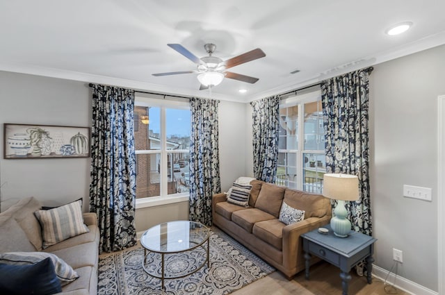 living area featuring wood finished floors, recessed lighting, crown molding, baseboards, and ceiling fan