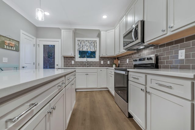 kitchen featuring tasteful backsplash, light countertops, light wood-style flooring, white cabinets, and stainless steel appliances