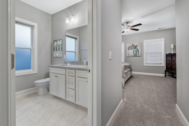 ensuite bathroom with a healthy amount of sunlight, baseboards, and ensuite bathroom