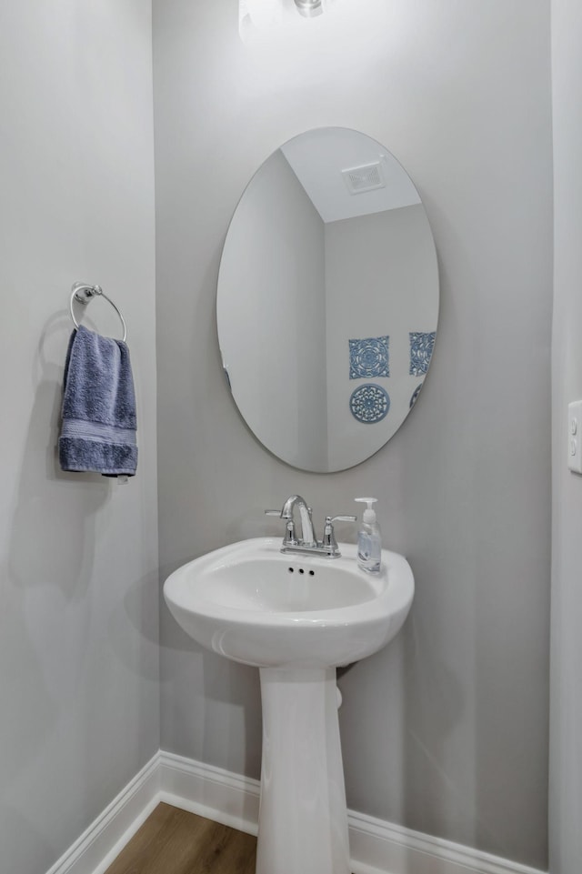 bathroom with baseboards and wood finished floors