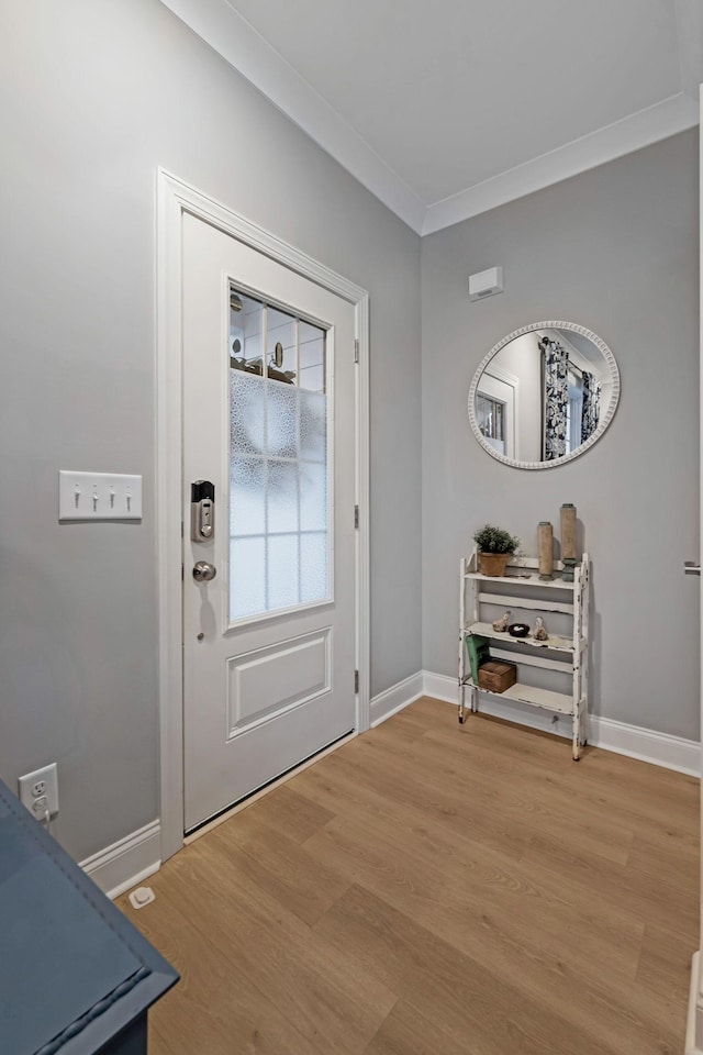 entryway featuring light wood-type flooring, baseboards, and crown molding