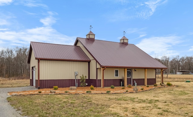 view of front of house featuring metal roof, a front yard, and a chimney