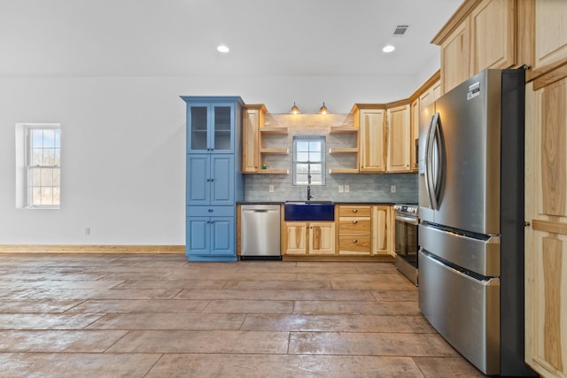 kitchen featuring light brown cabinetry, open shelves, dark countertops, appliances with stainless steel finishes, and decorative backsplash