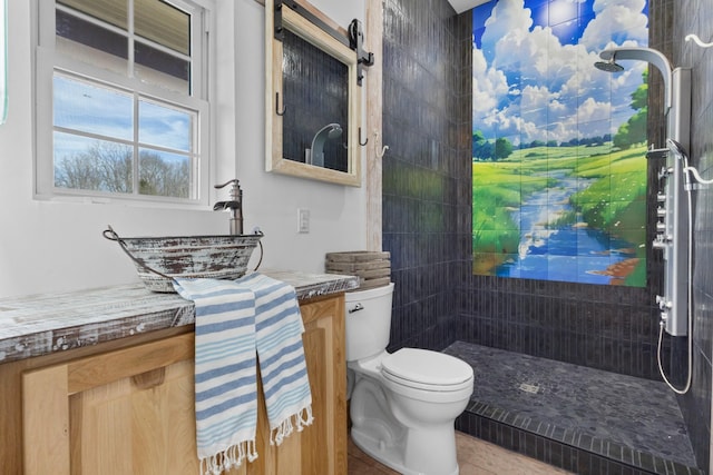 full bath with toilet, vanity, and a tile shower