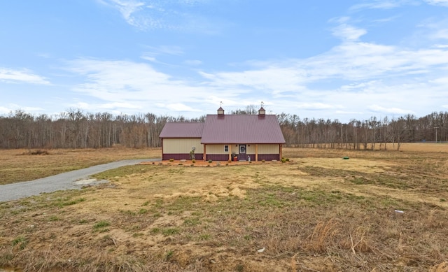 view of front of home with metal roof and a front lawn