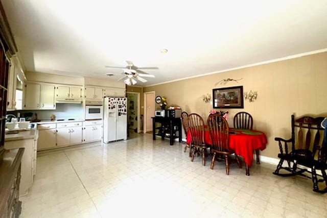 dining area featuring a ceiling fan, light floors, and ornamental molding