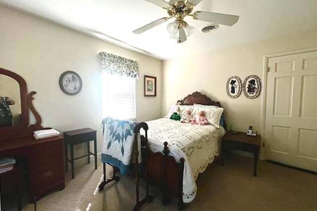 carpeted bedroom featuring visible vents and a ceiling fan