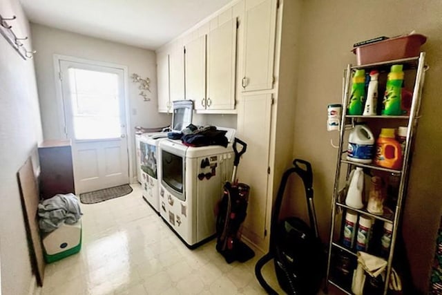 kitchen with white cabinetry, washing machine and dryer, and light floors