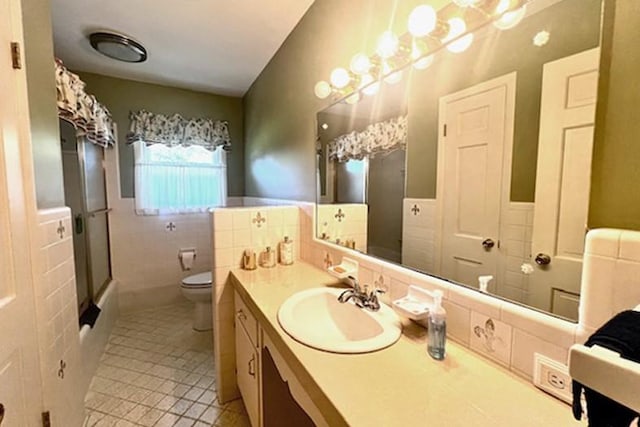 bathroom with a wainscoted wall, toilet, tile walls, and vanity