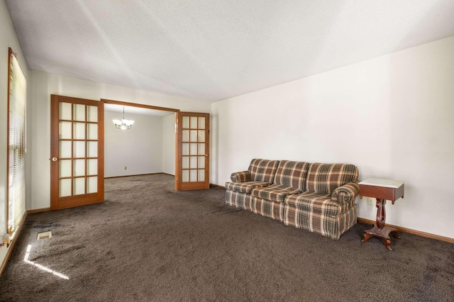 sitting room featuring french doors, carpet floors, and a chandelier