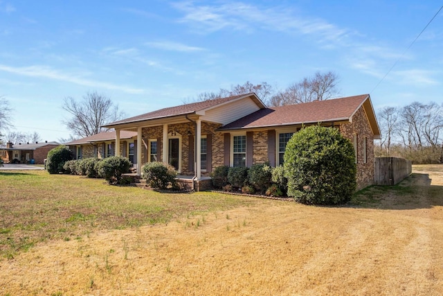 single story home featuring brick siding, a front yard, and fence