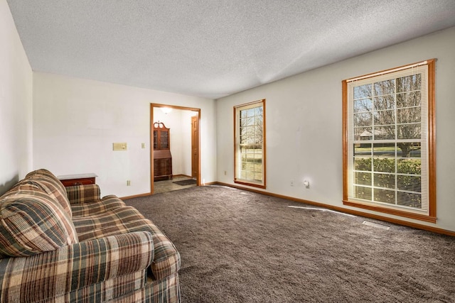 sitting room with baseboards, carpet floors, and a textured ceiling