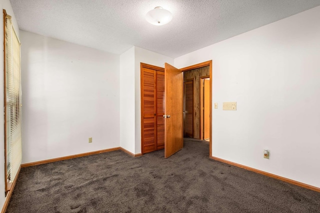 unfurnished bedroom with a closet, baseboards, carpet, and a textured ceiling