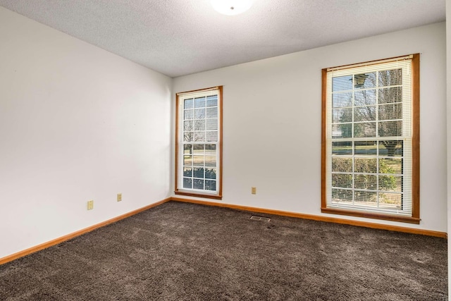 carpeted spare room featuring visible vents, baseboards, a textured ceiling, and vaulted ceiling