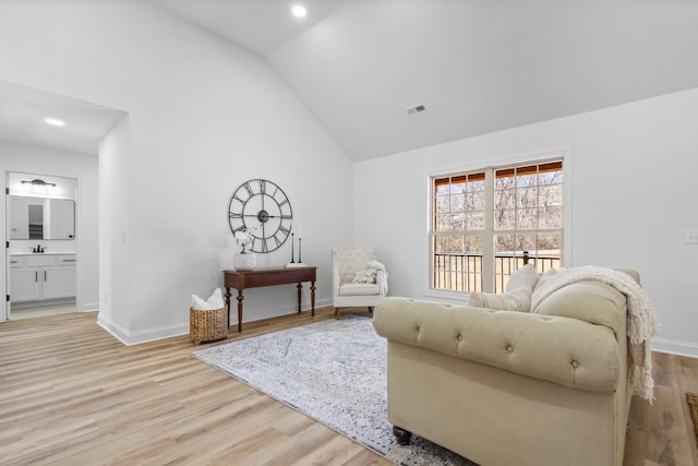 sitting room featuring visible vents, baseboards, high vaulted ceiling, and light wood-style flooring