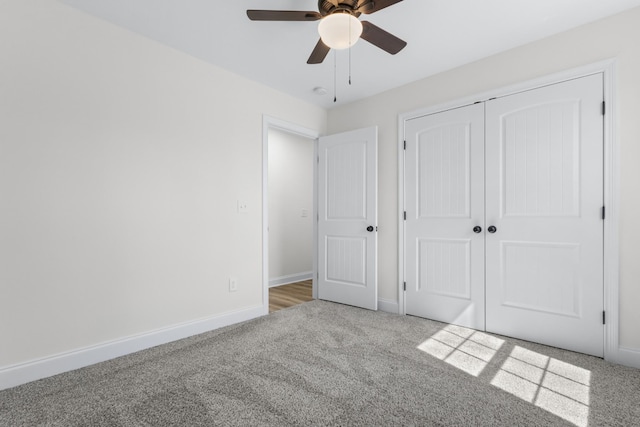 unfurnished bedroom featuring baseboards, carpet floors, a closet, and a ceiling fan