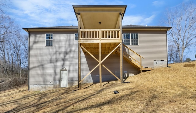 rear view of property with crawl space, a deck, and stairway