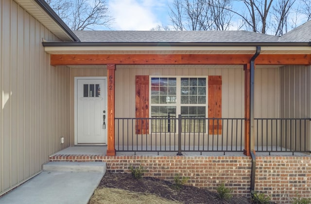 entrance to property featuring a shingled roof