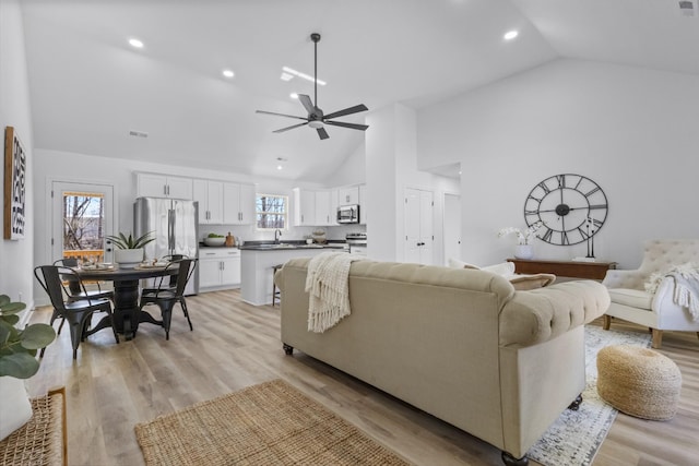 living room with recessed lighting, light wood-type flooring, high vaulted ceiling, and ceiling fan