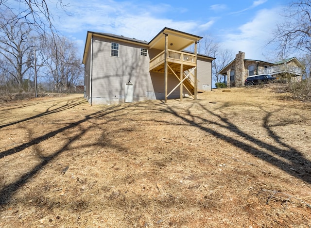 back of house with crawl space and a wooden deck