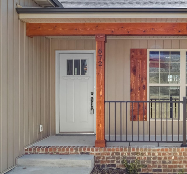 view of exterior entry featuring a shingled roof