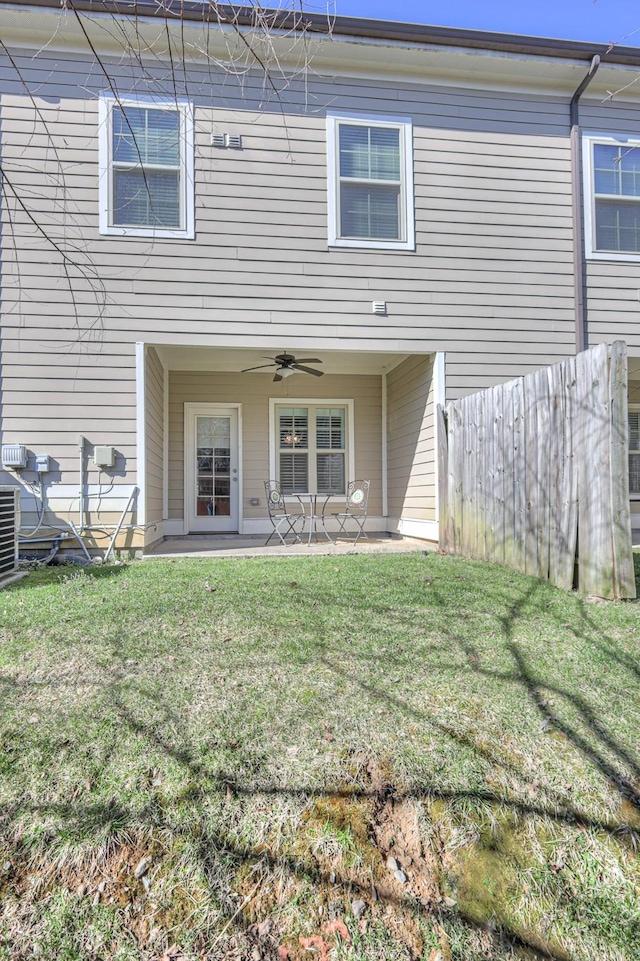 back of property with a yard, a patio, ceiling fan, and fence