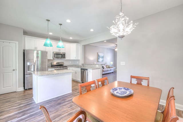 dining area featuring recessed lighting, ceiling fan with notable chandelier, baseboards, and dark wood-style flooring