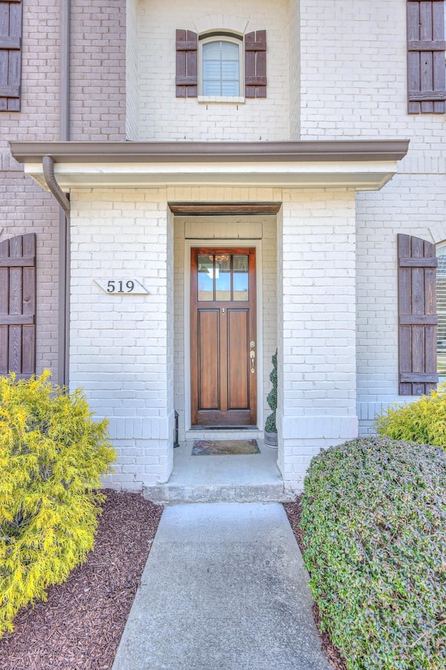 property entrance featuring brick siding