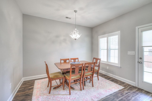 dining room with dark wood finished floors, an inviting chandelier, baseboards, and visible vents