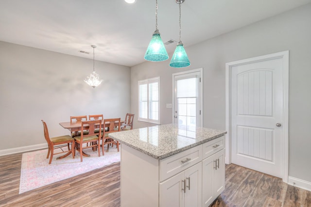 kitchen with light wood finished floors, visible vents, and hanging light fixtures