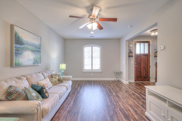 living room with dark wood-style floors, ceiling fan, and baseboards